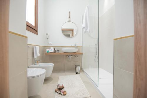 a white bathroom with a toilet and a sink at Ciuri Di Mari in San Vito lo Capo