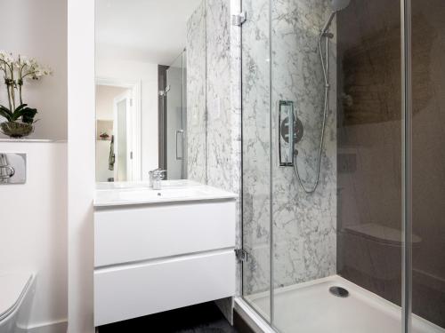 a white bathroom with a shower and a sink at Woodcock Farm in Bristol