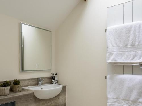 a bathroom with a sink and a mirror and towels at Woodcock Farm in Bristol