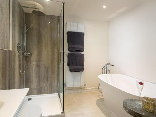 a bathroom with a shower and a bath tub at Woodcock Farm in Bristol