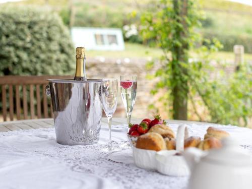a table with a bottle of wine and two glasses at Woodcock Farm in Bristol
