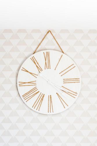 a white clock with roman numerals hanging on a wall at VILLA LA FORT BELLE VUE in Ambleteuse