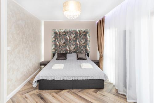 a bedroom with a bed with a headboard at GDAŃSK nad MOTŁAWĄ nowy Apartament Nadmotławie in Gdańsk
