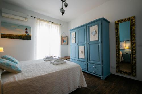 een slaapkamer met een blauwe kast en een bed bij S'Arena Dorada Deluxe Apartment in Alghero