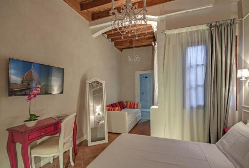 a living room with a bed and a table and a desk at Residenza d'epoca Borgo Albizi in Florence