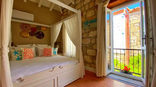 a bedroom with a bed in a room with a window at Maison d'Azur Alaçatı in Alacati