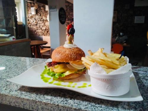 a cheeseburger and french fries on a white plate at Techas City Center Luxurious Suite in Praia