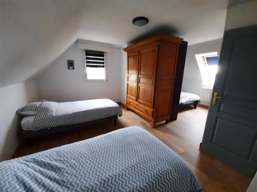 a bedroom with two beds and a wooden cabinet at VILLA LA FORT BELLE VUE in Ambleteuse