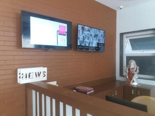 a dining room with a television on a wall at Season 4 Residences - Nungambakkam Near US consulate, Apollo Hospital, Shankar Nethralaya in Chennai
