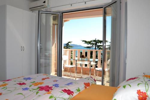 a bedroom with a bed and a view of a balcony at Montesun Residence in Herceg-Novi
