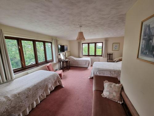 a bedroom with two beds and a couch in it at Burnt House Farm in Highbridge