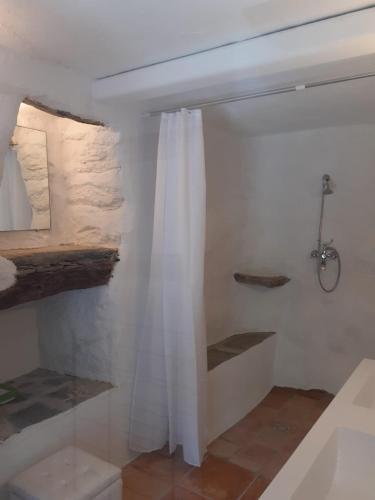 La salle de bains est pourvue d'une douche avec un rideau blanc. dans l'établissement La vagolo, à Luri
