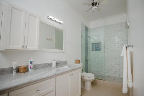 a bathroom with a sink and a toilet and a shower at Ocho Rios Penthouse at Whispering Seas in Ocho Rios