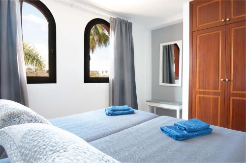 1 dormitorio con 2 toallas azules en 2 camas en Oasis Royal, en Corralejo