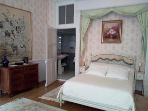 a bedroom with a bed and a dresser and a bathroom at Le Chateau de Prauthoy in Prauthoy