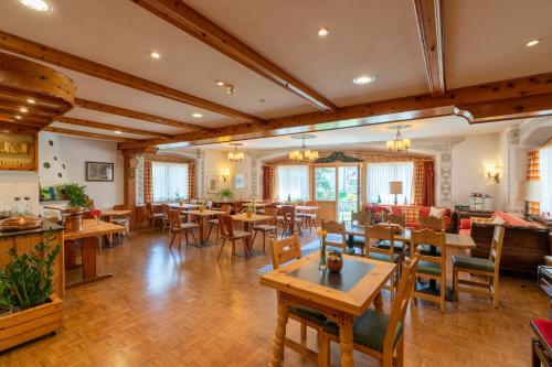 - un restaurant avec des tables et des chaises dans une salle dans l'établissement Hotel Alpina, à Zernez