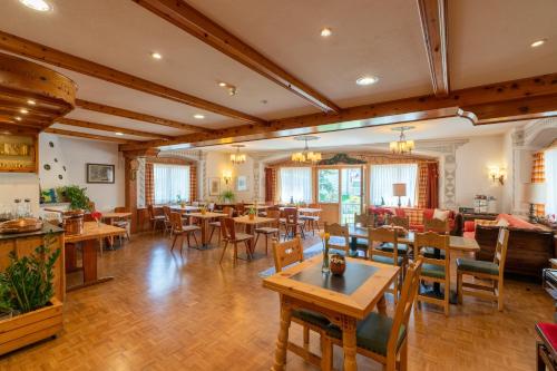 a restaurant with tables and chairs in a room at Hotel Alpina in Zernez