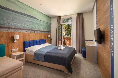 ein Hotelzimmer mit einem Bett und einem TV in der Unterkunft Hotel Solero in Siófok