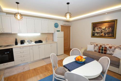 a kitchen and living room with a table and a couch at Apartments Olive in Kotor