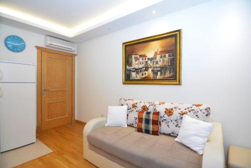 a living room with a couch and a painting on the wall at Apartments Olive in Kotor
