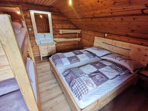 a bedroom with a bed in a wooden cabin at Almhütte Kristabauer in Predlitz