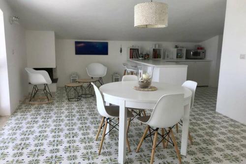 una sala da pranzo con tavolo bianco e sedie bianche di Mansarda Marinello a Oliveri