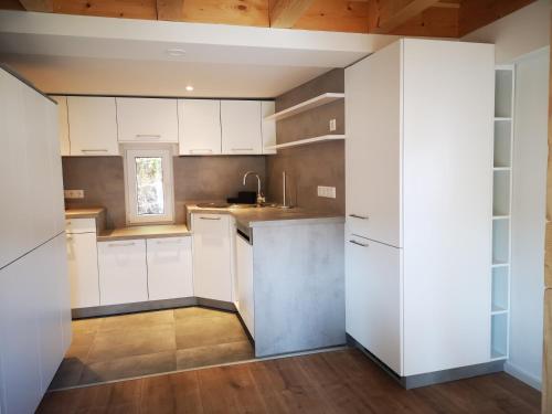 a kitchen with white cabinets and a wooden ceiling at Ferienhaus Elbsicht in Pirna