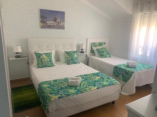 a bedroom with two beds and a bedskirts at Moradia Ricardo - Nazaré in Nazaré