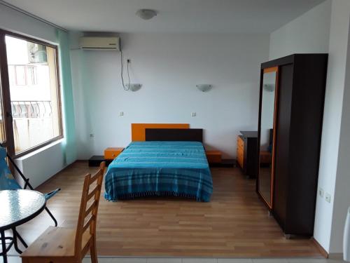 a bedroom with a bed and a table and a mirror at Apartment Comfort in Sunny Beach