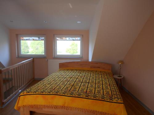 a bedroom with a bed and two windows at Ferienwohnung-Pension Werrablick in Witzenhausen