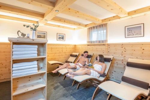 two people sitting in chairs in a sauna at Wawies Apartments in Flachau