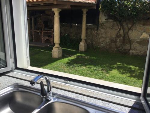 a kitchen sink and a window with a view of a yard at Room Villa Ribeiro pilgrims way to SANTIAGO bike a garage for Marinhas Esposende in Esposende