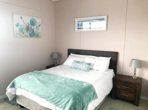 um quarto com uma cama com um edredão verde em Quayside 606 Durban Point em Durban