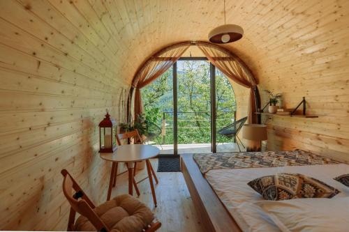 Cette chambre comprend un lit, une table et une fenêtre. dans l'établissement Woodhide - Cottages near Batumi, Georgia, à Zeda Ch'khutunet'i