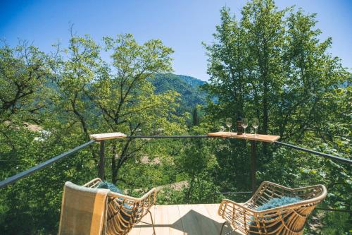 two chairs on a balcony with trees in the background at Woodhide - Cottages near Batumi, Georgia in Zeda Ch'khutunet'i