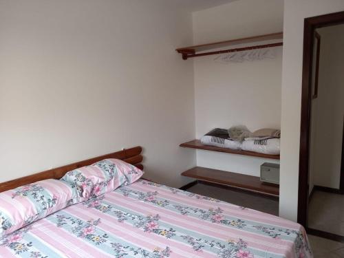 - une petite chambre avec un lit et une étagère dans l'établissement La Corte Residencial AC, à Porto Seguro