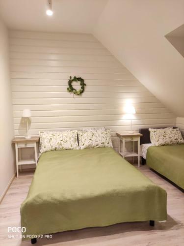 a bedroom with two green beds and two tables at Apartamenty u Kasi in Kudowa-Zdrój