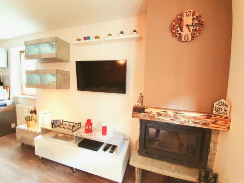 a living room with a fireplace and a tv at La casa di Matilde - trilocale vicinissimo alle piste da sci in La Thuile