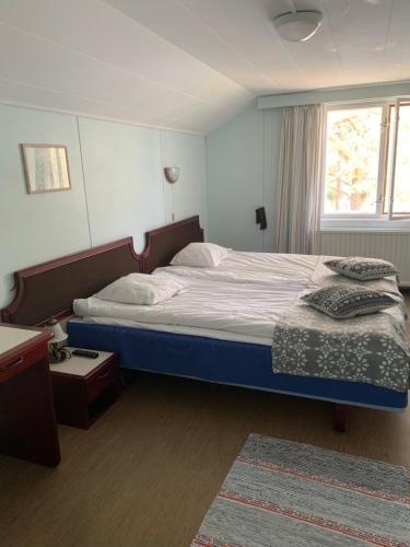 a bedroom with a large bed and a window at Hotel Laatokan Portti in Parikkala