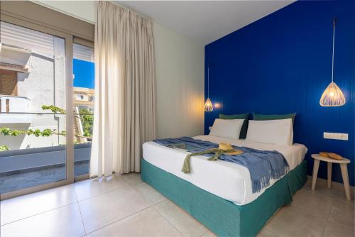 1 dormitorio azul con 1 cama con pared azul en Blue Horizon, en Palaiochóra