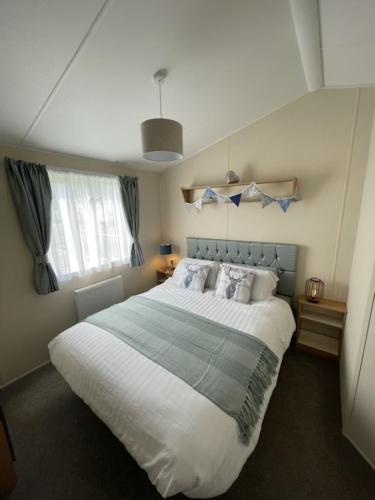 a bedroom with a large bed and a window at Hot Tub 9 The Fairways in Alnwick