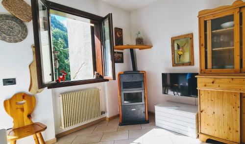 a living room with a tv and a window at Oseli22 in Lavarone