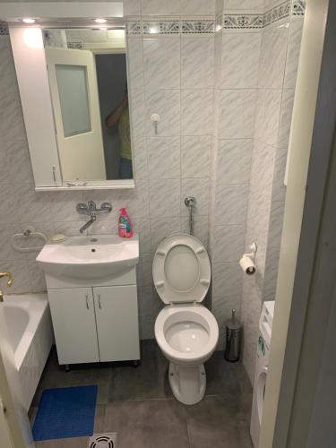 een badkamer met een toilet, een wastafel en een spiegel bij apartman Fuerte 2 in Belgrado