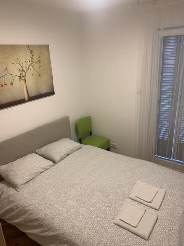 ein Schlafzimmer mit einem Bett und einem grünen Stuhl in der Unterkunft apartman Fuerte 2 in Belgrad