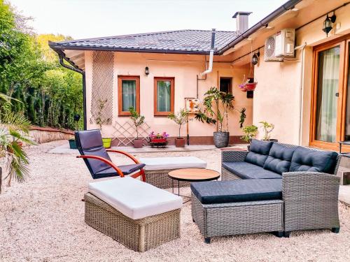a patio with chairs and a couch and a table at Paradise garden in Sarajevo