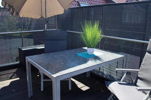 a table with a potted plant on a balcony at Ferienwohnung Auf der Blumenstrasse in Nettetal