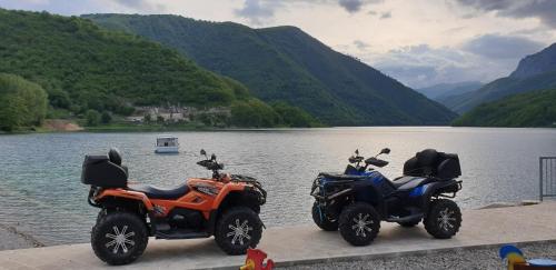 two motorcycles parked next to a body of water at Bungalow Holiday in Pluzine
