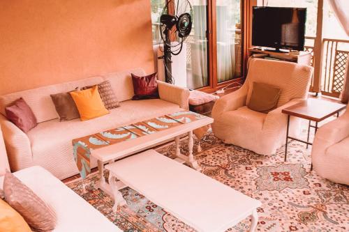 a living room with a couch and a table and chairs at Paradise garden in Sarajevo