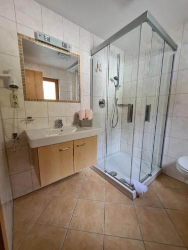 a bathroom with a shower and a sink at Pension Appartementhaus Bergland in Biberwier