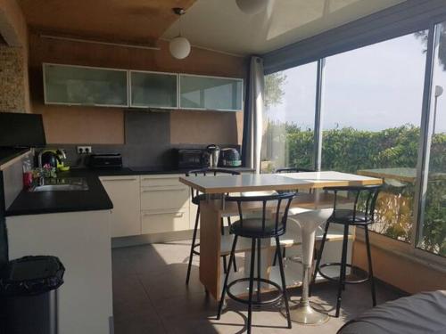 a kitchen with a table and chairs and a window at AJACCIO VUE MER ET MONTAGNES JACUZZI 300M PLAGEs in Ajaccio